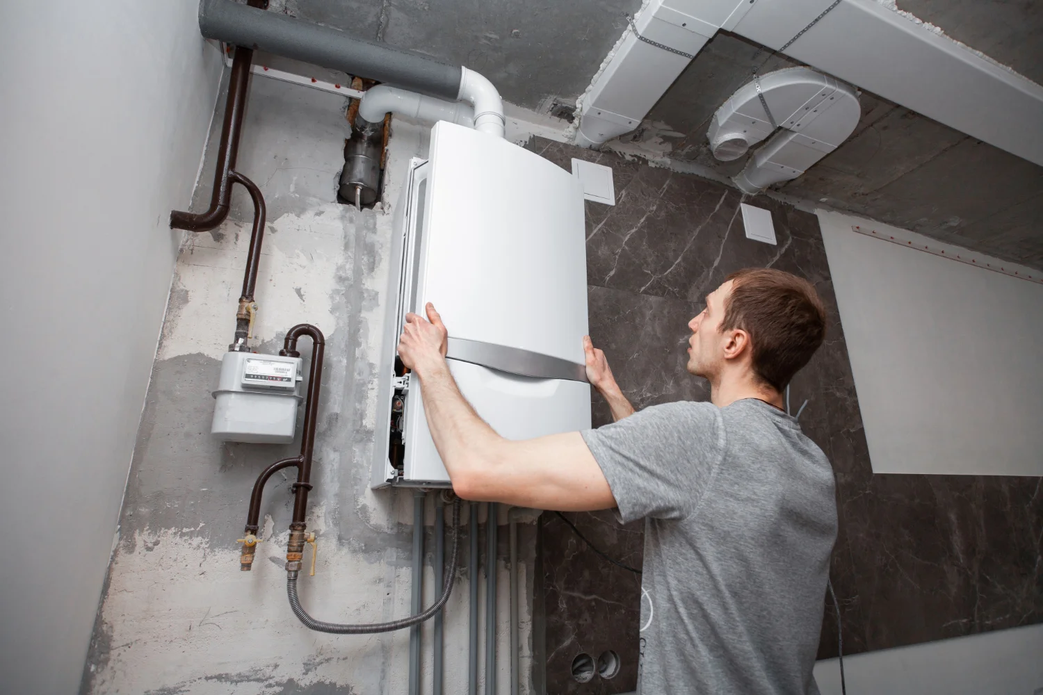 Engineer installing a wall-mounted boiler.