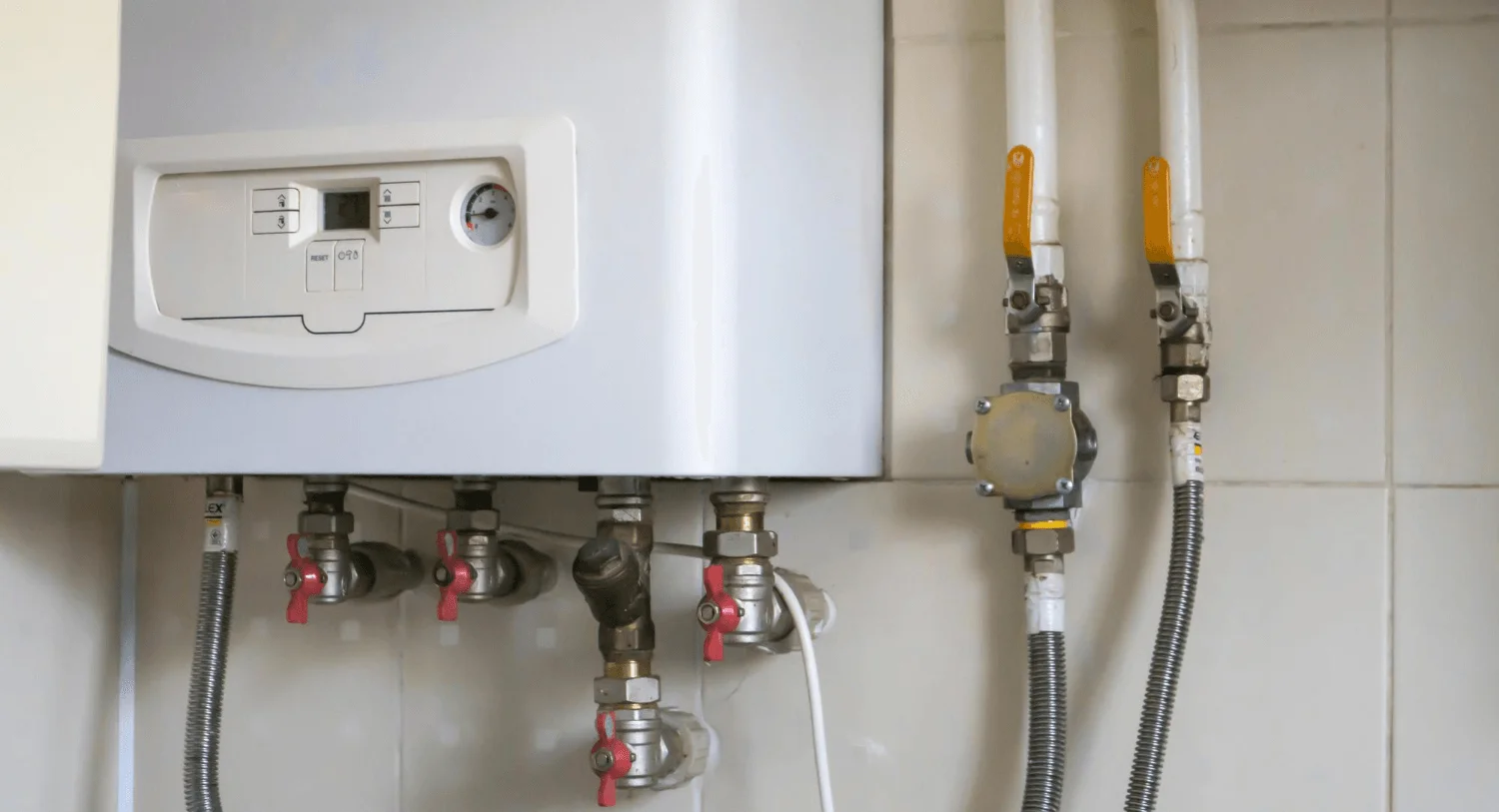 Residential gas boiler with connected pipes.
